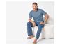 Homme en t-shirt et pantalon bleus assis sur une chaise blanche.