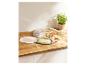 Barquettes en plastique avec fromage, saumon et viande, avec une plante en pot en arrière-plan.