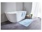 Une baignoire blanche avec un tapis de bain bleu dans une salle de bain moderne.