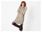 Femme rousse en robe pull beige et bottes marron.