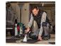 Homme nettoyant des tapis de voiture avec un aspirateur Parkside dans un garage.