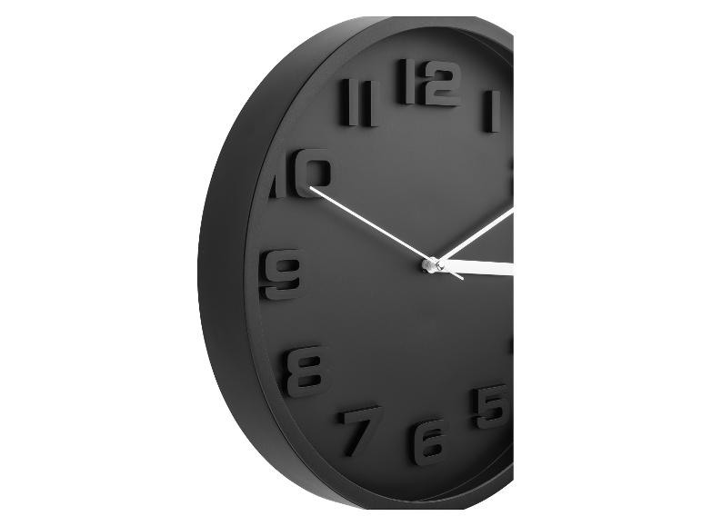 Horloge murale noire moderne avec des chiffres en relief.
