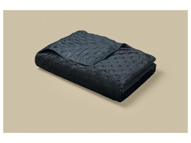 Couverture matelassée gris foncé pliée avec un motif subtil