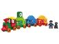 Un train jouet avec des chiffres et deux figurines.