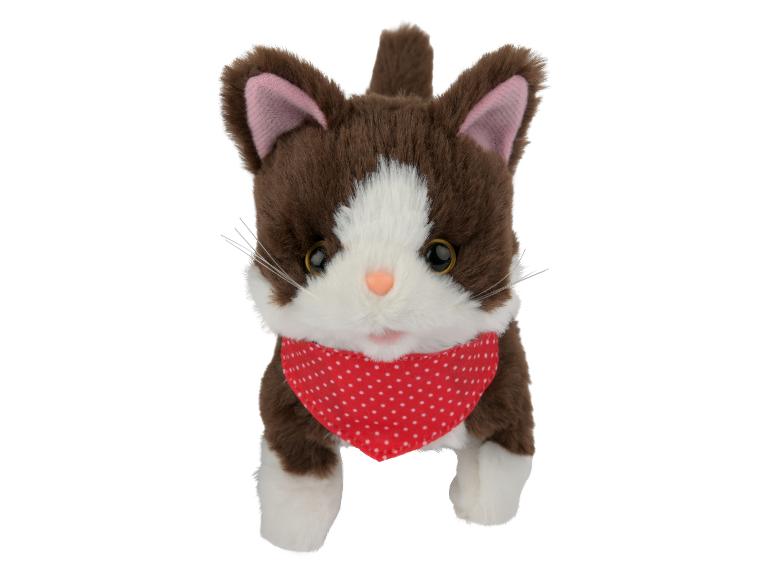 Un jouet en peluche de chat marron et blanc avec un bandana rouge à pois blancs.
