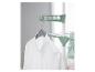 Une chemise blanche suspendue sur un séchoir à linge vert avec un cintre en bois.