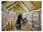 Homme coupant du bois dans une pièce en rénovation, éclairée par un tuyau lumineux LIVARNO®.