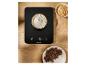 Balance de cuisine numérique noire avec un bol de farine, des noisettes et du chocolat haché.