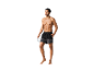 Un homme en short de bain et lunettes de soleil.