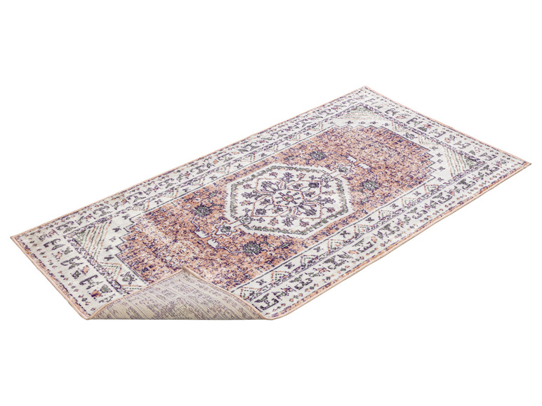 Un tapis rose et violet avec un motif traditionnel.