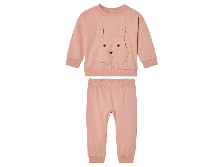 Un sweat-shirt rose avec des oreilles de lapin et un pantalon assorti.
