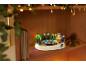 Décoration de Noël avec patinoire, arbres et lumières sur une étagère en bois.