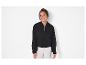 Une femme porte une veste bomber noire.