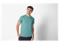 Un homme souriant porte un t-shirt turquoise avec une poche.