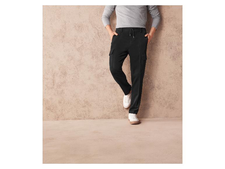 Pantalon cargo noir avec des baskets blanches.