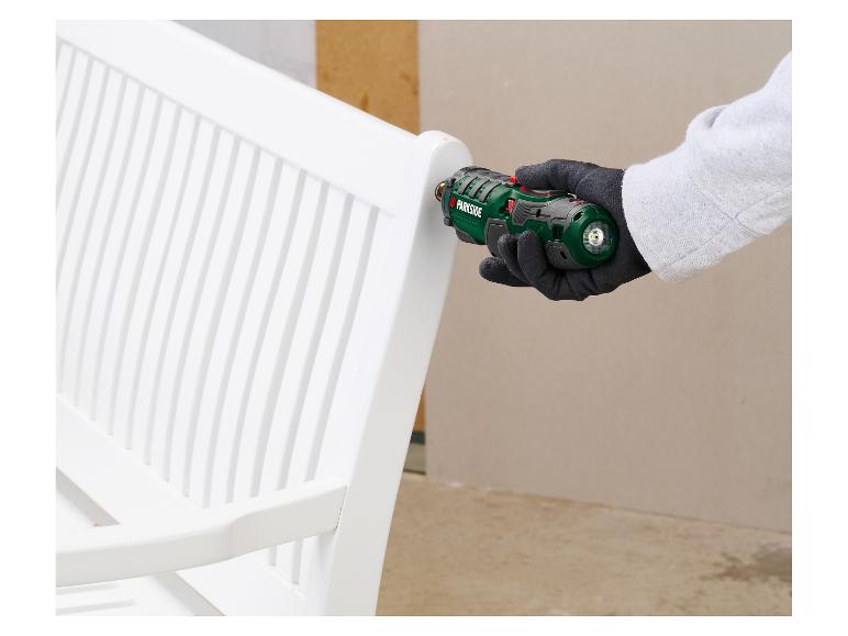 Personne utilisant une visseuse électrique pour assembler un banc de jardin blanc.