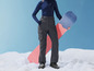 Une femme en tenue de ski avec un snowboard.