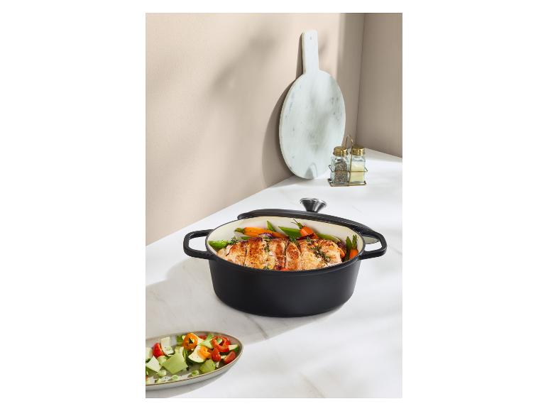 Cocotte noire avec rôti et légumes, accompagnée d'une salade.