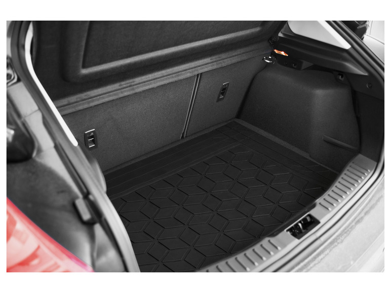 Un coffre de voiture avec un tapis de coffre en caoutchouc noir.