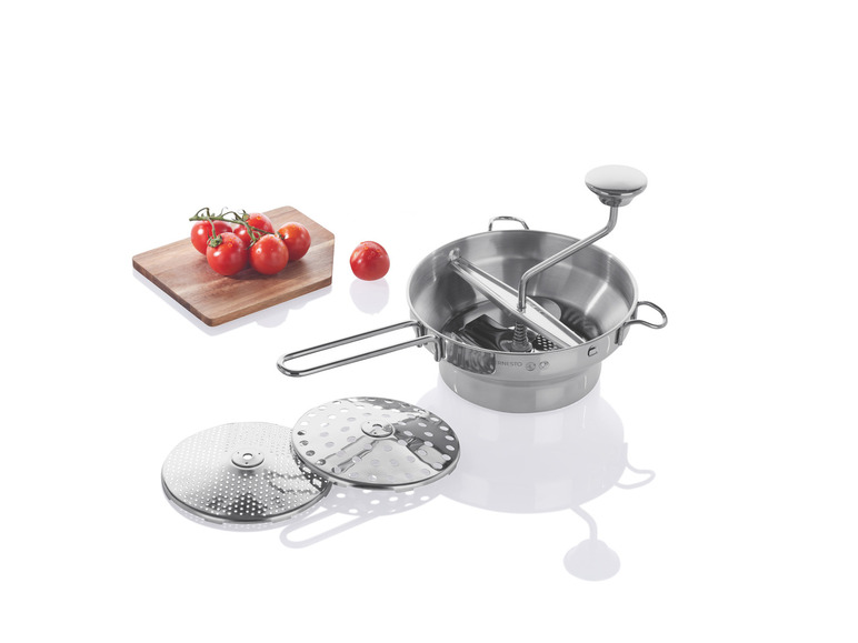 Une presse à pâtes manuelle Ernesto avec trois tamis et des tomates fraîches.