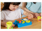 Un enfant joue avec de la pâte à modeler Play-Doh sur une planche à découper.