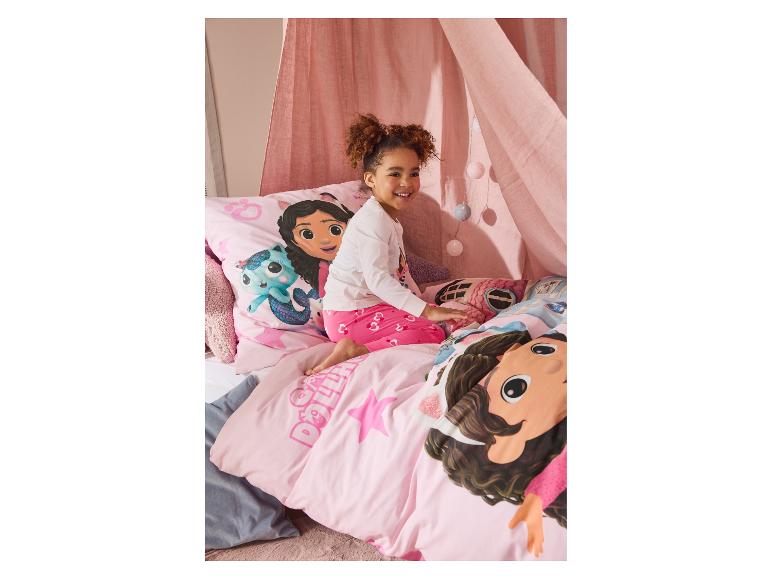 Parure de lit rose Gabby's Dollhouse et une fille souriante.