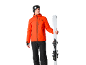Homme en veste de ski orange et pantalon de ski noir tenant des skis.