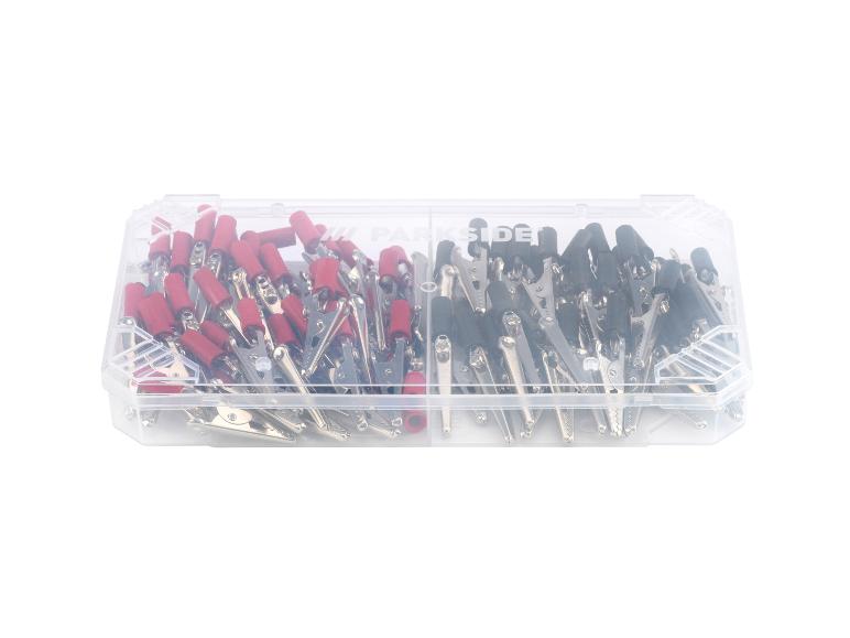 Une boîte avec des pinces crocodiles rouges et noires.