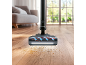 Aspirateur nettoyant un parquet avec de la saleté et des cheveux dans un salon.