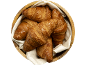 Croissants au beurre dorés et feuilletés dans un bol en bois avec un tissu blanc.