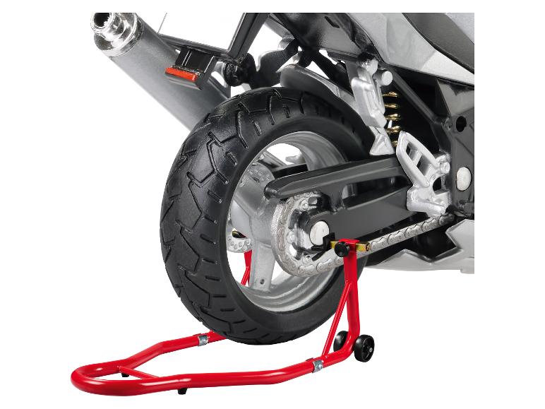 Arrière d'une moto sur un support rouge, montrant pneu, chaîne et échappement