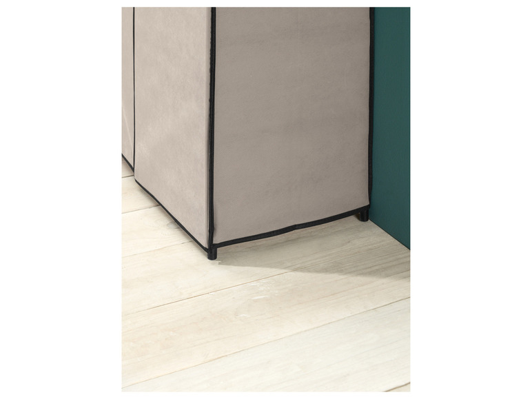 Une armoire en tissu beige avec des bordures noires.