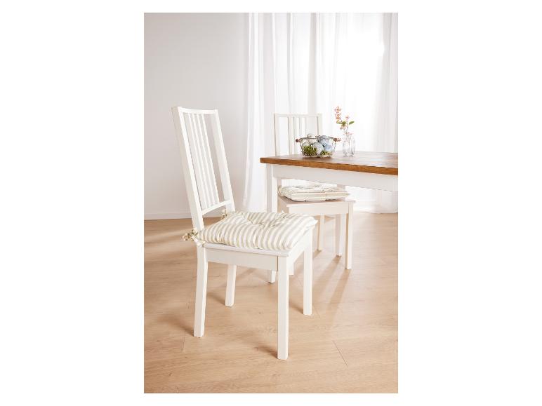 Deux chaises de salle à manger blanches avec des coussins rayés