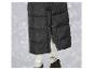 Une veste matelassée noire avec un pantalon argenté et des bottes noires.
