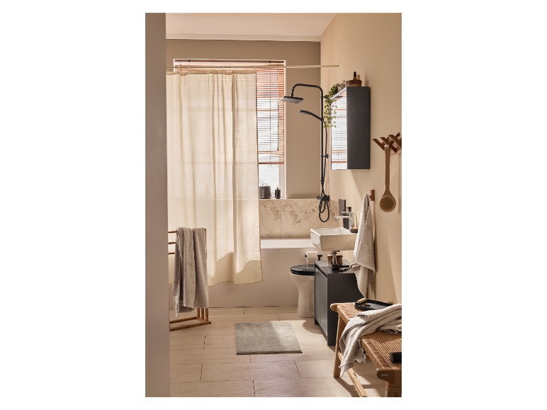 Une salle de bain moderne avec douche, lavabo et baignoire dans des tons clairs et neutres.