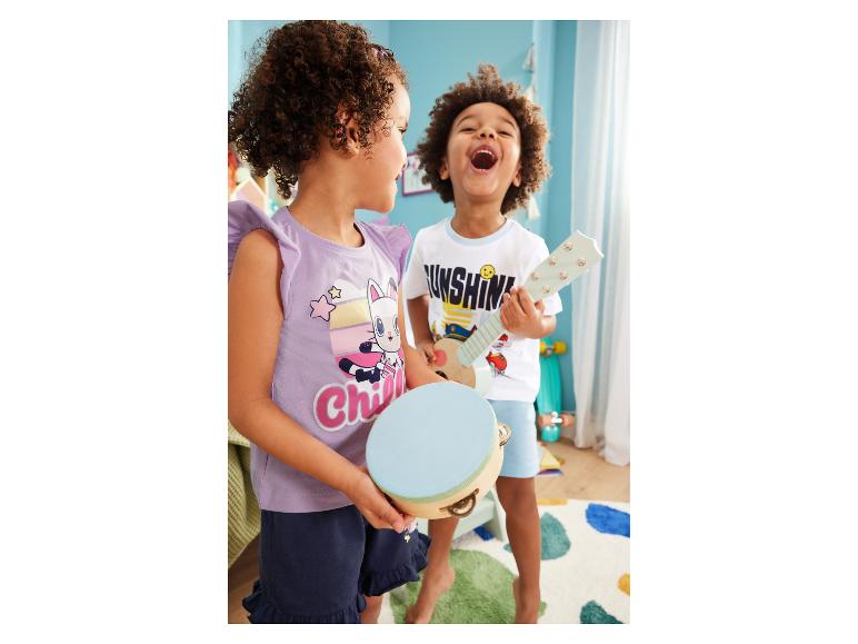 Enfants jouant avec tambourin et ukulélé ; vêtements à motifs enfantins.