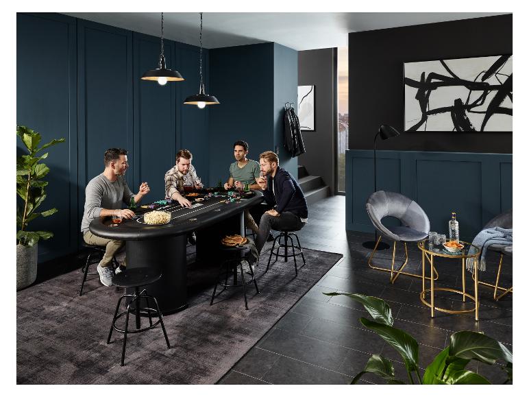Quatre hommes jouant au poker à une table de poker noire avec des chaises hautes.