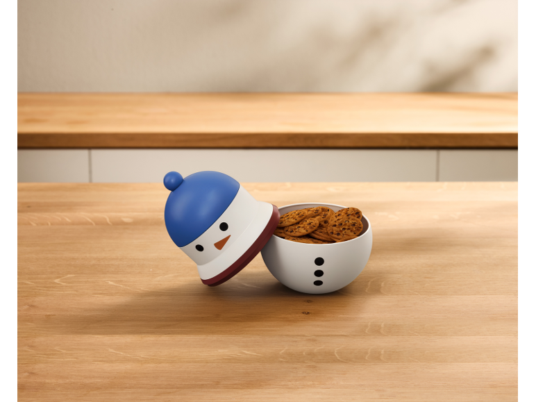 Boîte à biscuits en forme de bonhomme de neige remplie de biscuits sur une table en bois.
