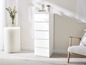 Une commode blanche avec cinq tiroirs dans un salon moderne.