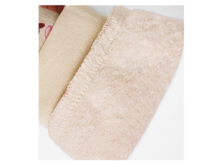 Gros plan sur un poignet en tricot beige avec doublure en polaire douce.