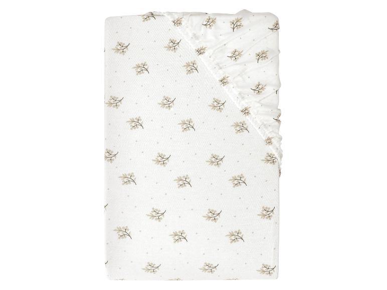 Drap de lit bébé à motif floral.