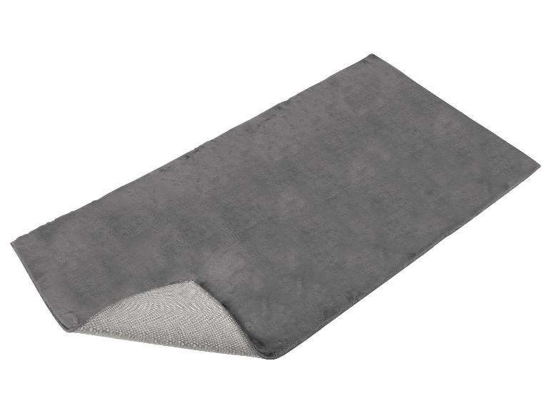 Un tapis gris avec une texture douce et moelleuse.