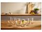 Six verres d'eau sur une table en bois, un avec du citron et de la menthe.