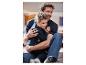 Un père et son fils, tous deux en tenue décontractée, rient ensemble.