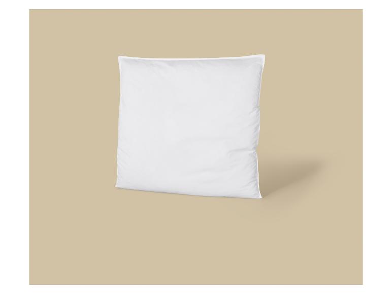 Oreiller blanc sur fond beige