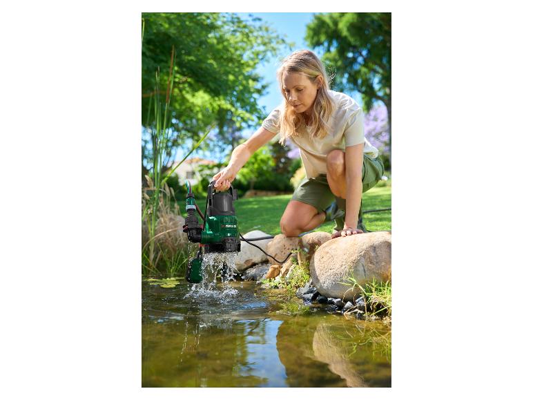 Femme utilisant une pompe submersible pour nettoyer un bassin de jardin.