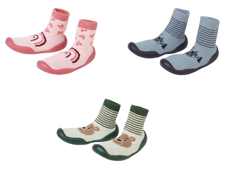 Trois paires de chaussons bébé avec différents motifs.