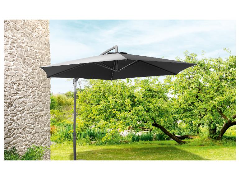 Parasol de jardin gris foncé, fixé au mur, dans un jardin verdoyant.