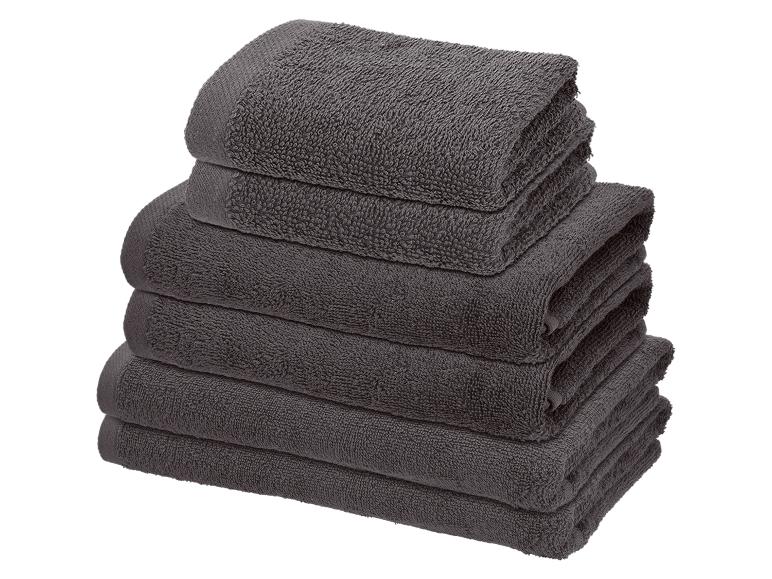 Pile de serviettes grises pliées de différentes tailles.