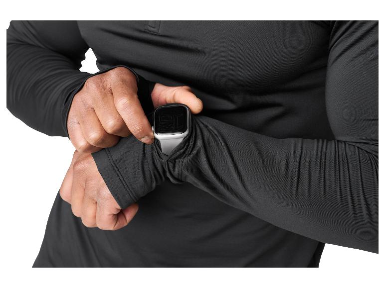 Homme en chemise noire à manches longues vérifiant une montre connectée.